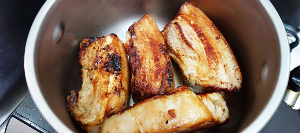 全体的に焼き目を付けた豚バラブロックをお鍋に並べたところ。
