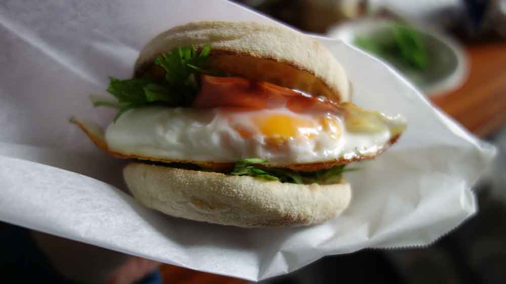 ヤマザキのロイヤルイングリッシュマフィンで月見バーガー的なもの。クッキングシートを折って包み紙にする。